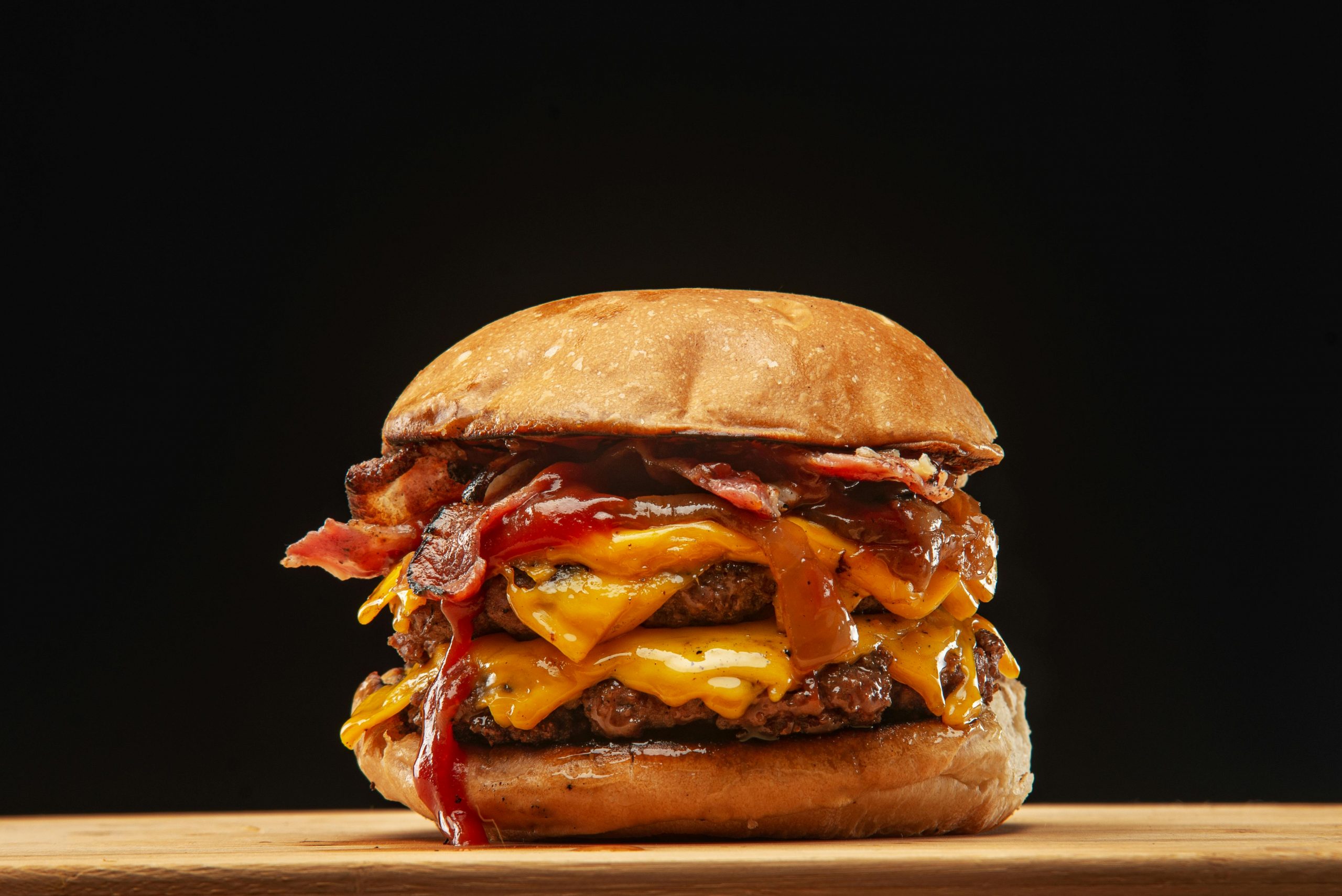 Indulge in a juicy double cheeseburger with bacon and melted cheese, perfect for food lovers.